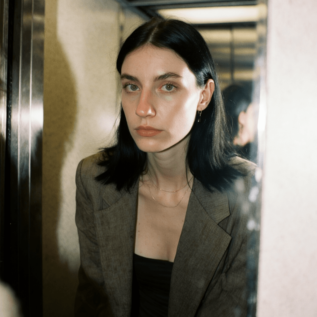 Emma-Jane MacKinnon-Lee — mirror self portrait, straight black hair tucked behind the ear Emma-Jane MacKinnon-Lee — mirror self portrait, straight black hair tucked behind the ear